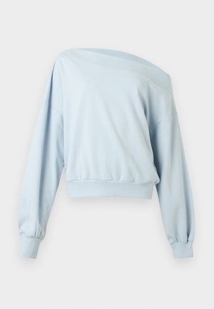 Pull bleu clair à manches longues épaules dénudées avec poignets et ceinture côtelés, présenté à plat sur un fond blanc.