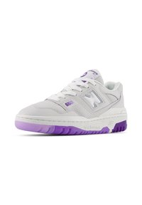 Sneaker bianco in pelle con dettagli viola, pannelli laterali perforati, lacci bianchi piatti, suola intermedia bianca spessa e suola esterna viola testurizzata.
