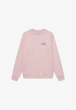 Hanorac roz deschis cu decolteu rotund, mâneci lungi și manșete cu nervuri. Prezintă un text grafic mic, verde, pe față. Textură de țesătură moale.