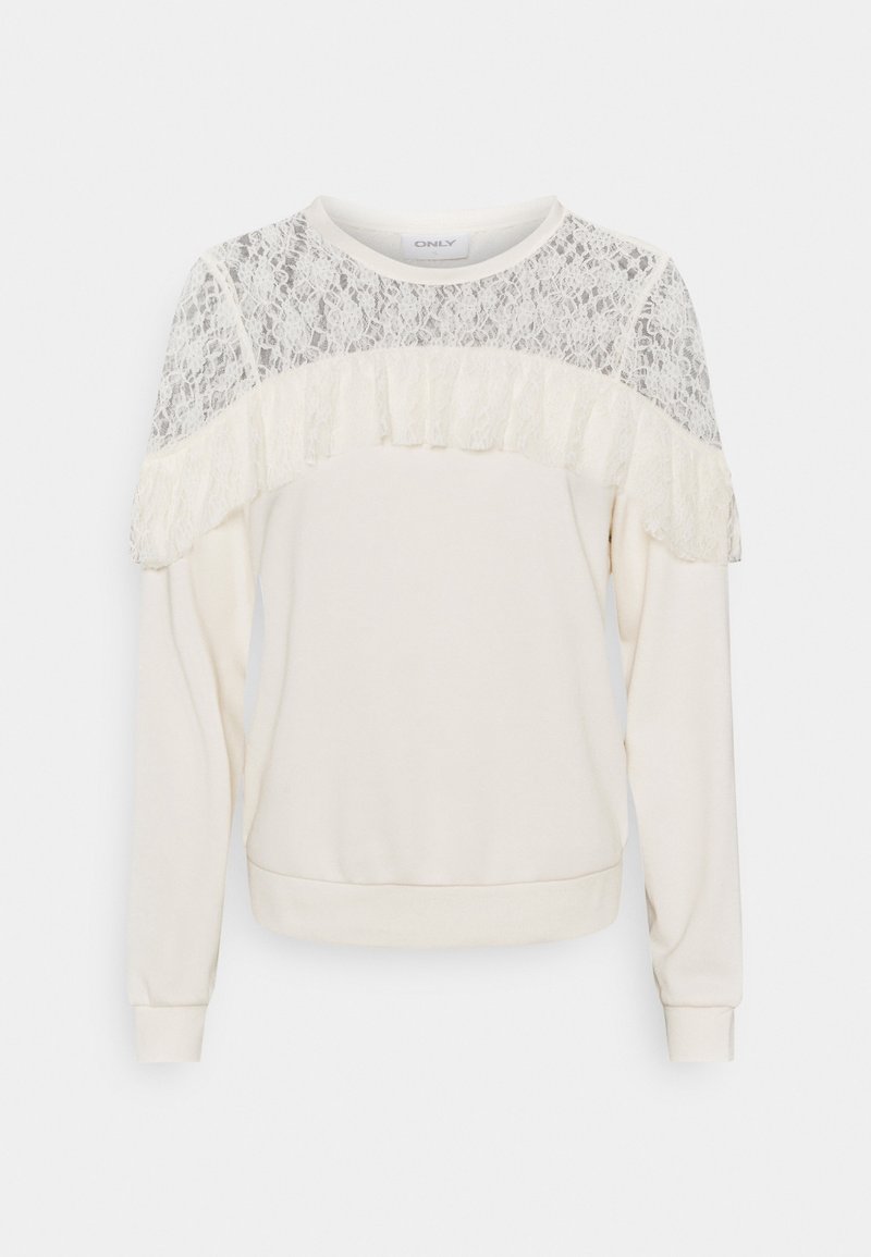 Krémový svetr s dlouhými rukávy, krajkovou yoke a volánkovým detailem přes hruď a ramena, přízovou manžetou a lemem.