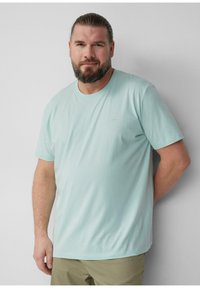 Miętowa koszulka z miękkiego materiału, z okrągłym dekoltem, krótkimi rękawami, z subtelnym detalem logo na klatce piersiowej.