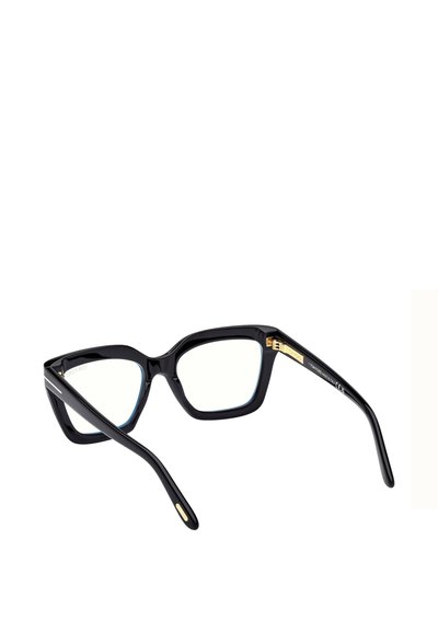 Lunettes œil de chat avec une monture en acétate noir brillant, des verres transparents, des accents dorés sur les branches et un design élégant.
