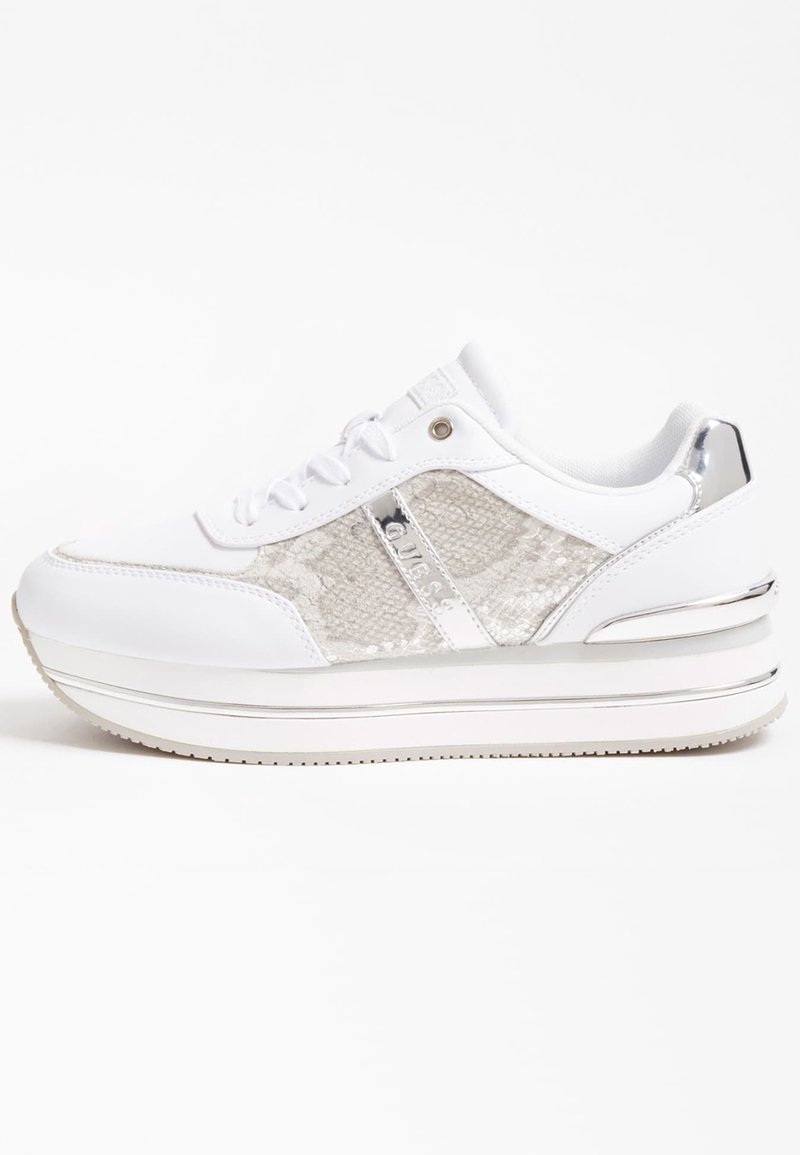 Bílé tenisky s lesklým stříbrným akcentem, texturovanými stranami a vrstvenou platformovou podrážkou. Mají šňůrky a jemné detaily značky.