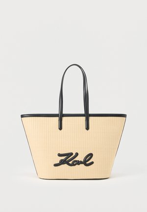 Šviesiai ruda austinė rankinė su juodomis odinėmis rankenomis ir apvadais, antkin fronto – juodas kursyvinis "Karl" logotipas.