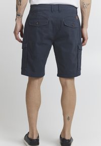 Shorts cargo bleu marine en tissu durable, dotés de plusieurs poches et d'une coupe décontractée, avec une finition lisse et sans motifs visibles.