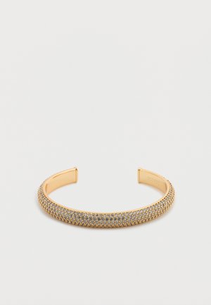 Gull-tonet mansjettarmbånd med en teksturert overflate pyntet med små glitrende steiner, glatte kanter og et minimalistisk design.