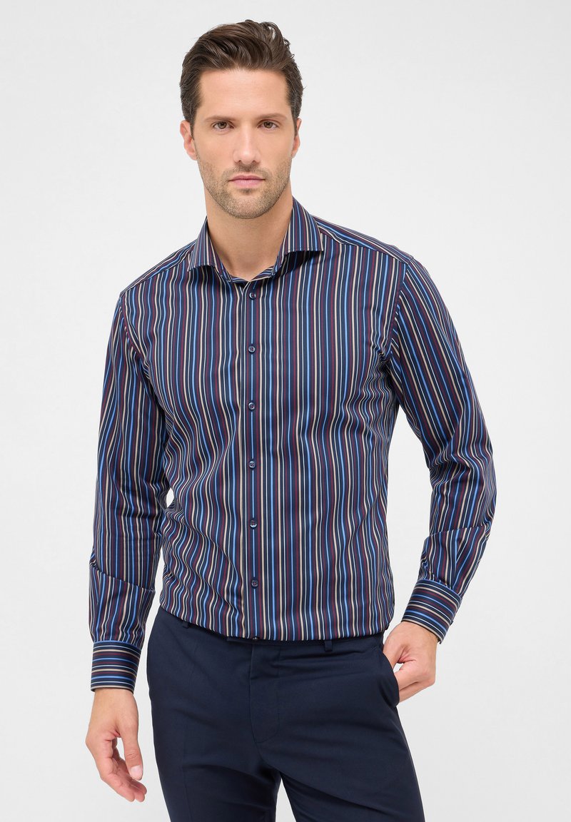 Camicia da uomo button-up di colore blu scuro, con strisce verticali in rosso, bianco e blu chiaro. Tessuto liscio con maniche lunghe e colletto a punta.