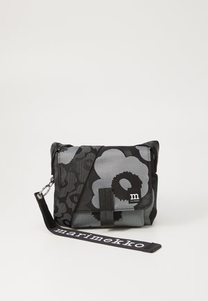Black and gray floral print bag with adjustable strap. Made of durable fabric, features a front flap and logo detail. Compact and structured design.