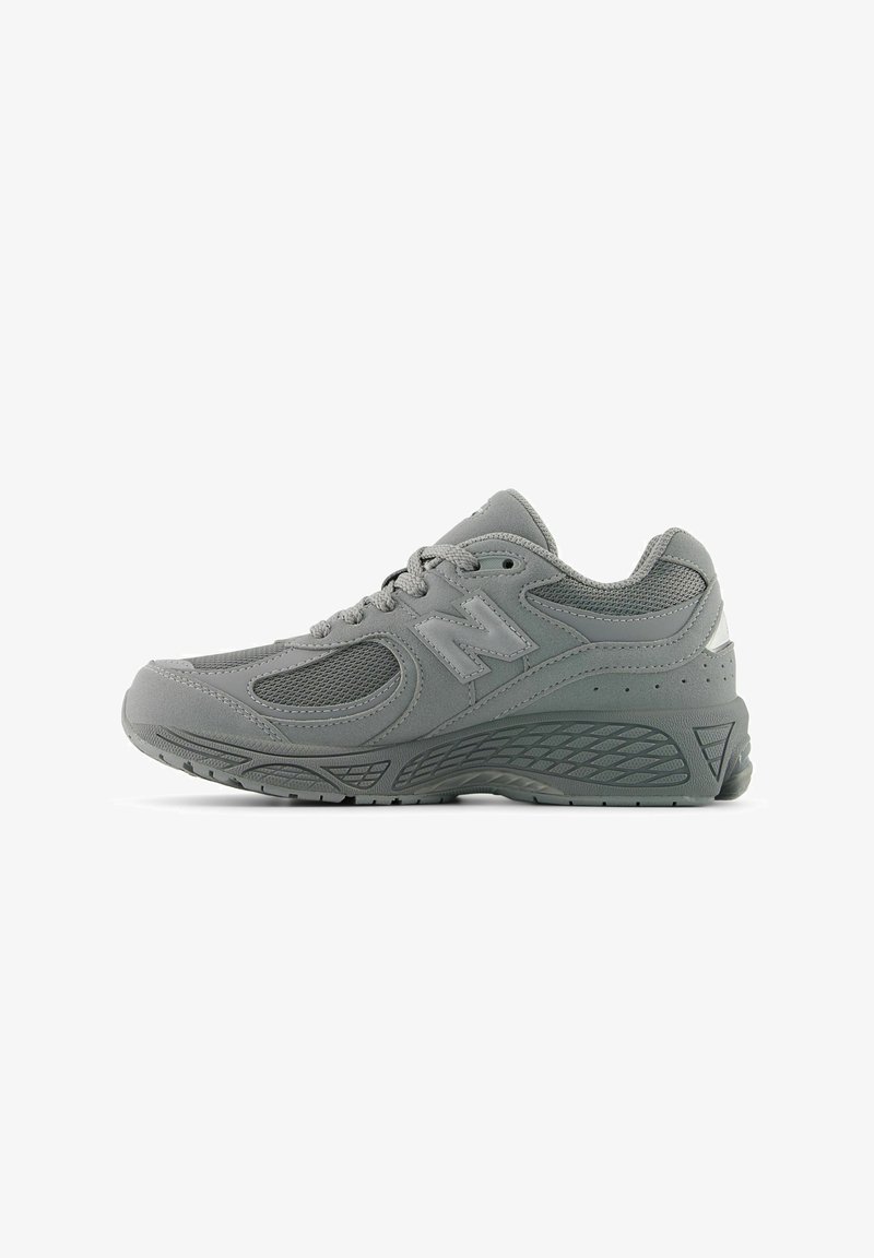 Baskets athlétiques grises avec panneaux en mesh et en daim, fermeture à lacets, semelle rembourrée et logo de la marque sur le côté.
