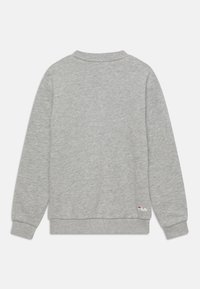 Sudadera gris con cuello redondo, mangas largas y puños acanalados. Presenta un pequeño logotipo en la parte inferior derecha. Textura de tela suave.