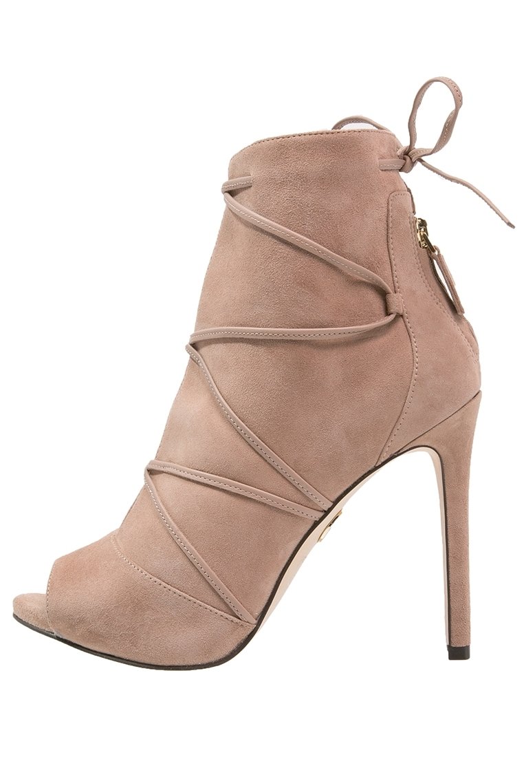Beige suede ankelstøvle med åben tå, høj stilettohæll og krydset remme. Har en lynlås i siden og snørrebånd ved anklen.