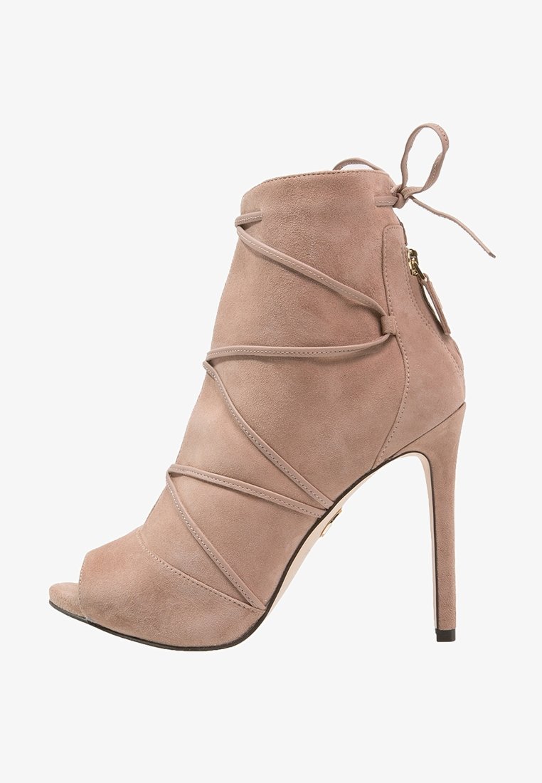 Beige suede ankelstøvle med åben tå, høj stilettohæll og krydset remme. Har en lynlås i siden og snørrebånd ved anklen.