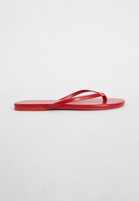 Raudoni guminių šlepetės su plokščiu padu. Yra minimalistinės blizgios juostos, skirtos kasdieniam dėvėjimui ir paplūdimio naudojimui.