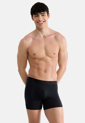 Sorte boxershorts med logo på taljebåndet, lavet af blødt materiale. Designet har en tætsiddende pasform og midt-lår længde.