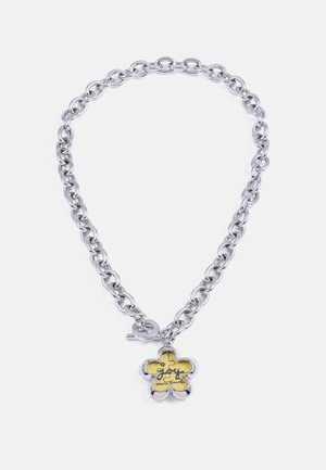 Chunky silver chain necklace with a five-petal flower charm featuring a yellow background and black cursive text.