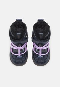 Mörkblå högskafflade stövlar med en glänsande yta, utrustade med fuskpälsfoder och lila elastiska snören för säker passform och komfort.