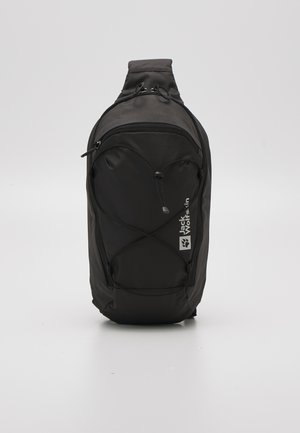 Zwarte compacte schouderrugzak met ritssluitingen en een verstelbare riem, met een Jack Wolfskin-logo op het voorvak.