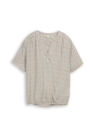 Blouse beige à manches courtes avec motif abstrait de lignes noires, encolure en V avec patte de boutonnage, posée à plat sur fond blanc.