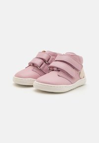 Rosa lær sko med hvite gummisåler, utstyrt med to justerbare borrelåsremmer og en teksturert aksent på siden.