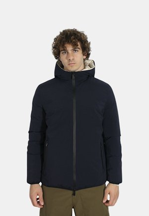 Giacca imbottita blu con cappuccio, dotata di chiusura con zip, tasche laterali e un rivestimento di colore chiaro a contrasto. Texture liscia e design moderno.