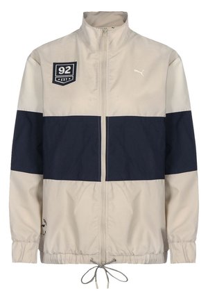 Beżowa i granatowa kurtka z pełnym zamkiem błyskawicznym z przodu, elastycznymi mankietami, ściągaczem na dole i naszywkami z napisem "92 EST" oraz logo Puma.