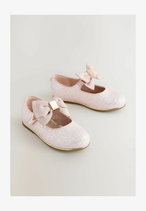 Iskrivo roza baletne balerinke z okroglim sprednjim delom, izrezanimi stranicami, velikim pentljastim detajlom in zlatim poudarkom na pentlji.