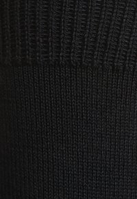 Schwarzer Strickstoff mit geripptem Muster an der Oberseite. Die gesamte Oberfläche ist glatt und zeigt eine einheitliche Farbe ohne Muster.