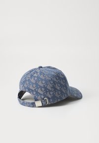 Blue cap made of fabric featuring a patterned design. It has a curved brim, adjustable strap, and a metal accent at the back.