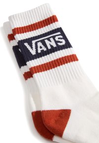 Valkoiset sukat, joissa on punaisia ja laivastonsinisiä vaakaraitoja, ja yläosassa suuri "VANS"-logo. Ribattu texture varressa.