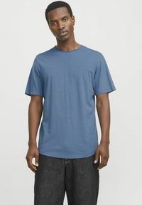 Blue short-sleeve T-shirt made of lightweight fabric, featuring a round neckline and a relaxed fit. Textured surface with subtle variations.