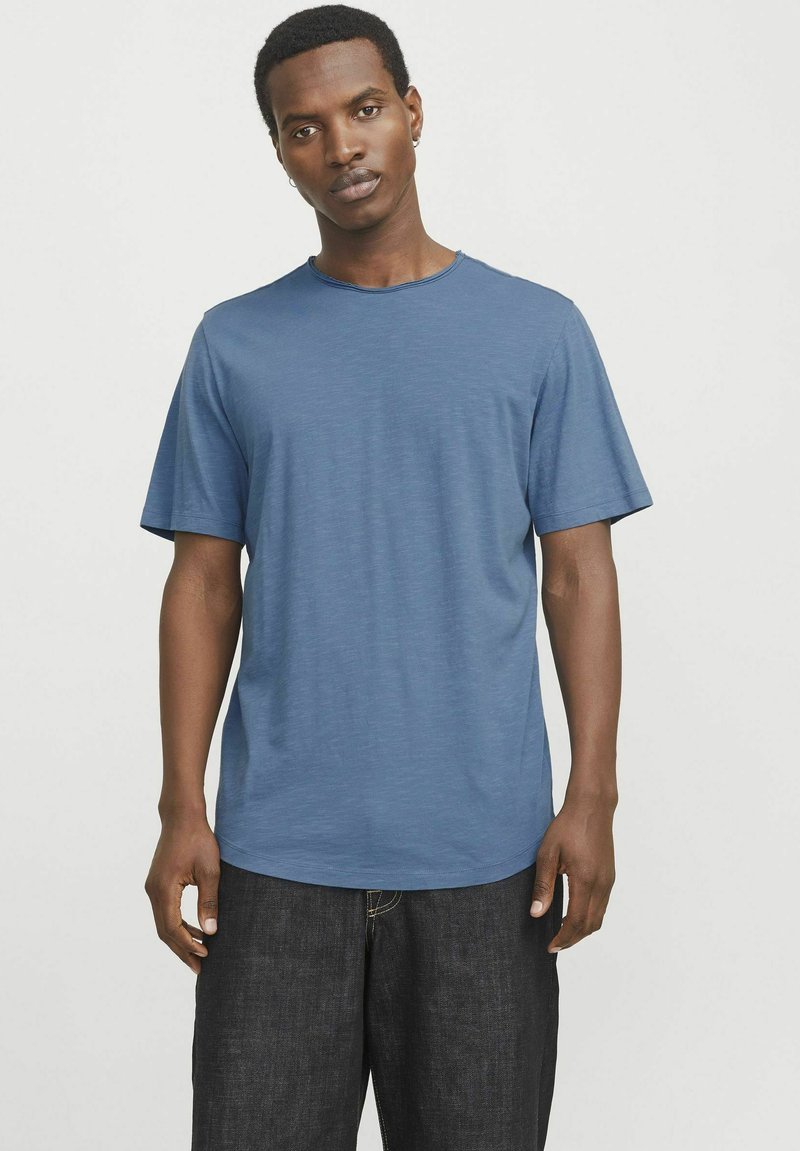 Blue short-sleeve T-shirt made of lightweight fabric, featuring a round neckline and a relaxed fit. Textured surface with subtle variations.