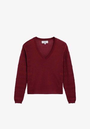 Bordeauxrode trui met V-hals en lange mouwen, voorzien van gestructureerde geometrische patronen op de mouwen en met geribbelde boorden aan de mouwen en hals.