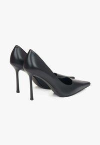 Czarne skórzane szpilki z ostrym noskiem i wycięciami, z cienkim obcasem w stylu stiletto oraz gładką fakturą.