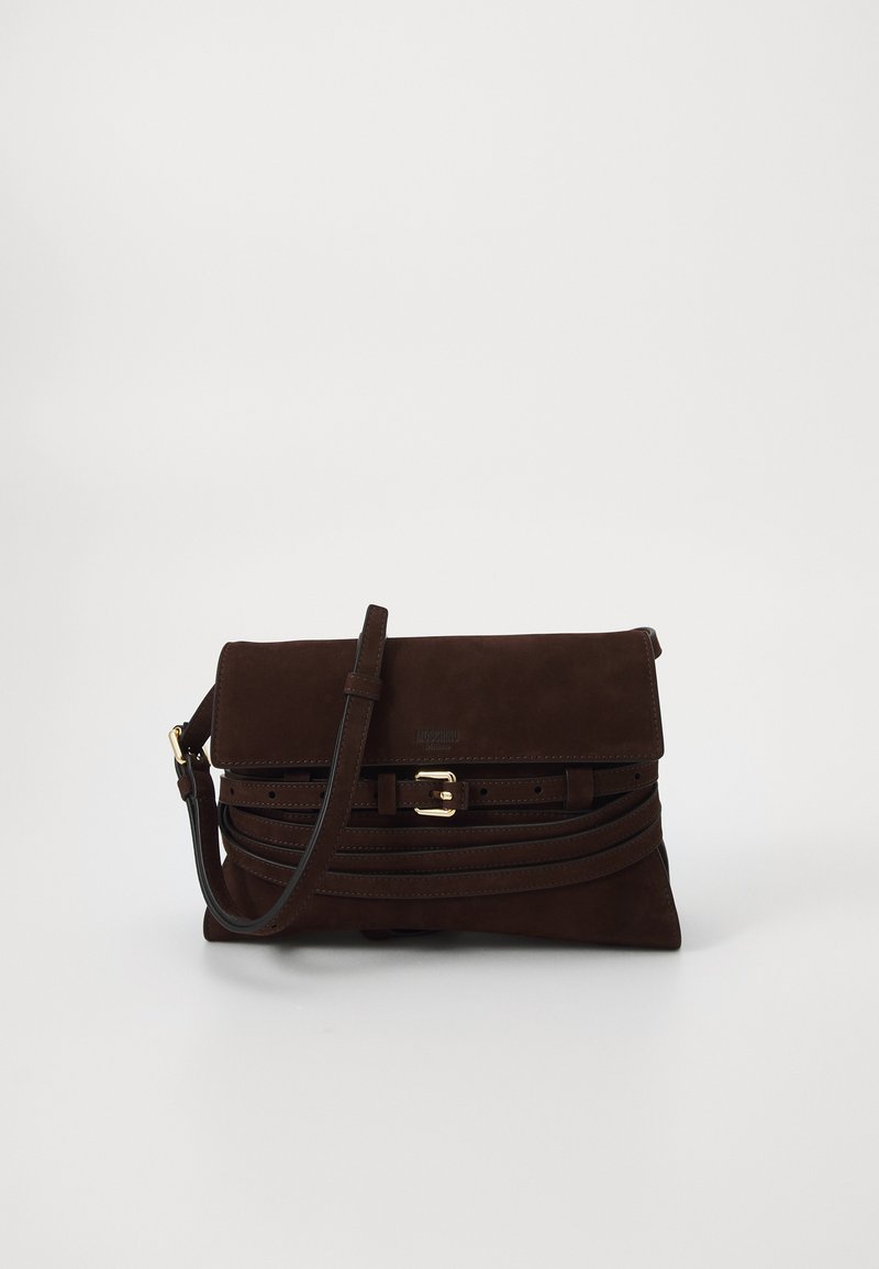 Tmavě hnědá semišová kabelka na klopu se zlatou sponou a nastavitelným ramenním popruhem, umístěná na bílém pozadí.