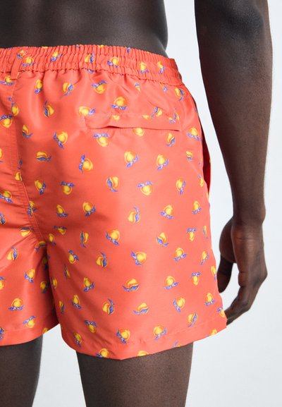 Røde svømmeshorts med et gentagne mønster af gule ferskner med blå blade, elastisk talje og sidelommer samt baglomme.