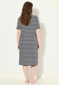 Randig knälång klänning i marinblått och vitt, med korta ärmar och en avslappnad passform. Mjukt tyg med en slät textur.