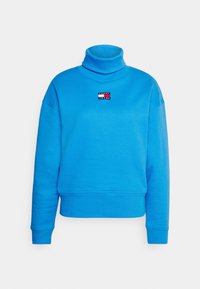 Niebieski sweter z golfem wykonany z mieszanki bawełny, o skróconym kroju, z małą naszywką z logo na piersi. Miękka faktura.