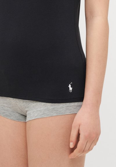 Black cotton tank top with scoop neckline and a small white logo. Paired with light gray cotton shorts featuring a folded hem.