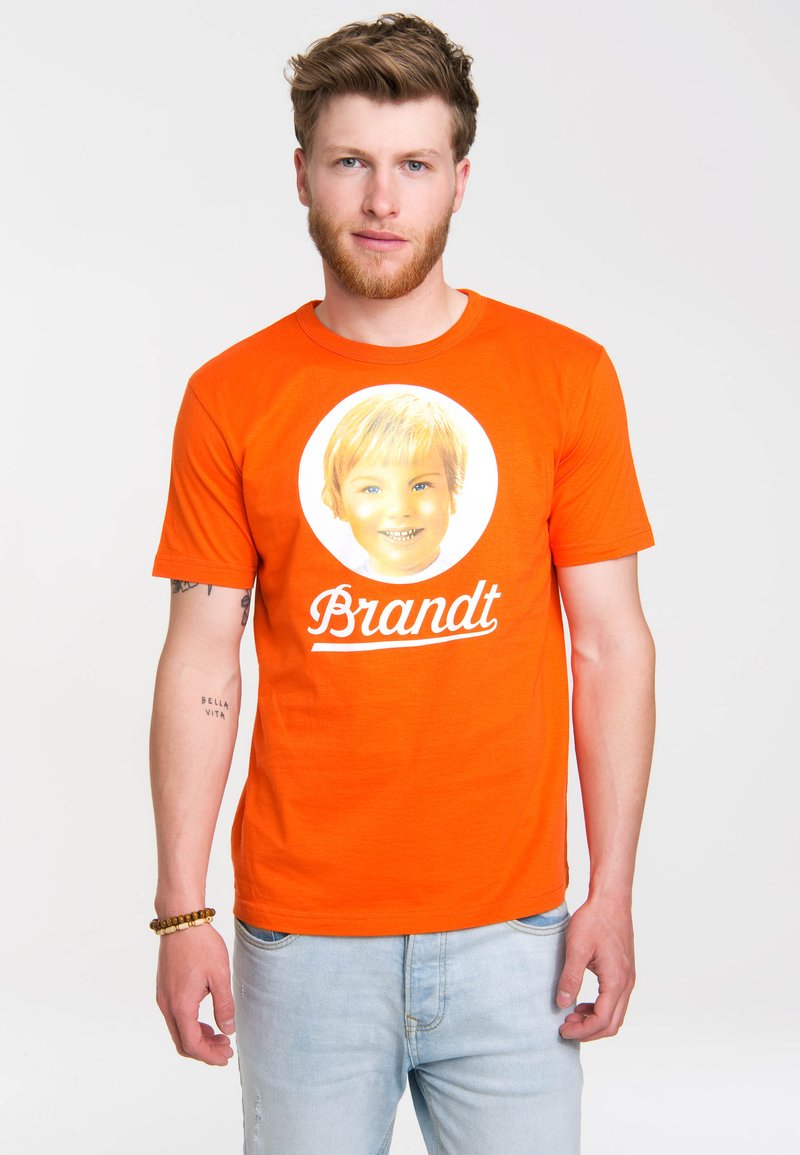 Orange cotton T-shirt featuring a circular graphic of a smiling child’s face with blonde hair, accompanied by the word "Brandt" in white script.