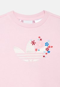 Ανοιχτό ροζ φούτερ με στρογγυλή λαιμόκοψη και κεντημένο λουλουδένιο σχέδιο σε κόκκινο, μπλε και λευκό, με κλασικό λογότυπο. Μαλακή υφή.