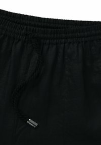 Czarne lniane szorty z elastyczną talią i sznurkiem do regulacji, z metalowymi akcentami. Gładka faktura z minimalnymi zmarszczkami.