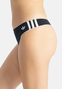 Svart bikiniunderdel med vit tre-randig design och logga på midjebandet. Slät tyg, måttlig täckning och elastiska kanter för passform.