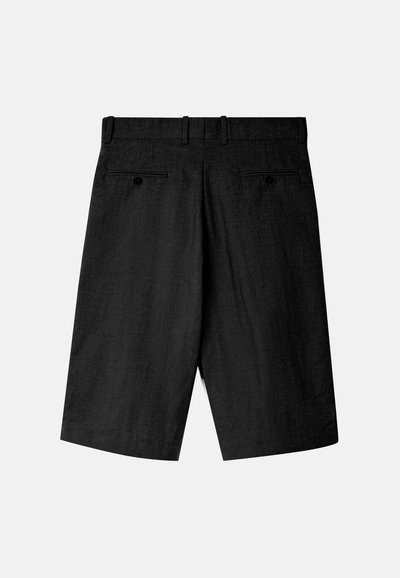 Pantalones cortos negros de tela texturizada, con un frente plano, dos bolsillos traseros con botones y un corte de longitud media.