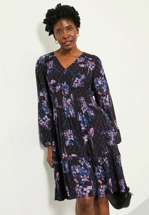 Schwarzes Blumenkleid mit langen Ärmeln, V-Ausschnitt, gerafftem Oberteil und gestuftem Rock, verziert mit lila und blauen Blumenmustern.