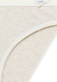 Beżowa bawełniana bielizna o miękkiej teksturze, z białym elastycznym wykończeniem i małym detalem w postaci kokardki na pasku. Metka brzmi "ATLANTIC".