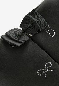 Pochette en tissu noir avec une finition texturée, ornée d'un grand nœud en ruban noir et d'accents en cristal formant une forme de nœud sur la surface.