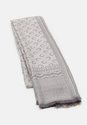 Tissu plié de couleur gris clair avec des motifs en forme de fer à cheval et des motifs géométriques gris plus foncé, présentant des bords frangés.
