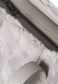 Grijze handtas van nepbont met een soepel lederen draagband, voorzien van een ritssluiting en een met zacht materiaal gevoerde binnenkant.