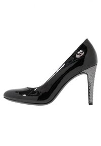 Zapato de tacón alto de charol negro con punta redondeada y un tacón geométrico plateado texturizado, que presenta un logo en el costado.