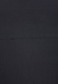 Zwart stof met een gladde textuur en een lichte glans. Heeft een schone, uniforme oppervlakte met subtiele stiksels over de bovenkant.